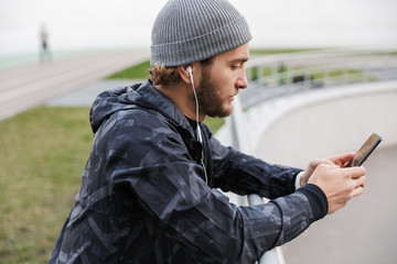 Motivated young fit sportsman listening to music