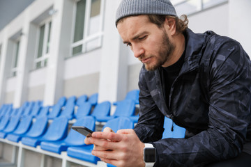 Confident young sportsman sitting on tribune seats at the stadium © Drobot Dean