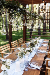 Festive table. The festive table is decorated with flowers, greenery, candles, a blue tablecloth, crystal plates, glasses and cutlery