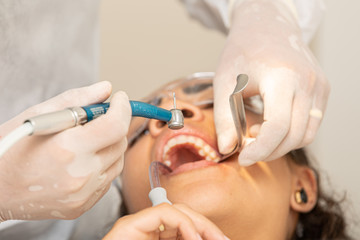 Young woman being seen in a dentist's office. Concept of toothache, wisdom tooth extraction,...