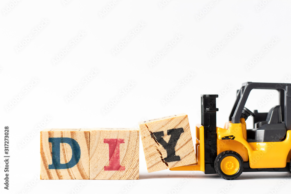 Wall mural Toy forklift hold wood letter block Y to complete word DIY (Abbreviation of Do it yourself) on white background