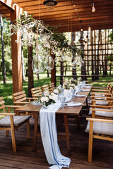 Festive table. The festive table is decorated with flowers, greenery, candles, a blue tablecloth, crystal plates, glasses and cutlery