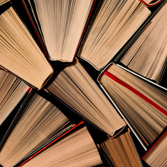 Books. Lots of colourful thick open books stand on a dark background