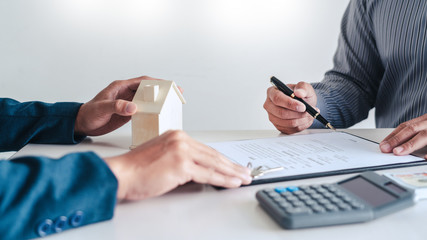 Real estate agents explain the document for customers who come to contact to buy a house, buy or...
