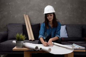 Business woman engineer portrait. Architect worker protect helmet waring. Busy and work hard. She ware red and black table shirt.