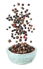 Different peppercorns falling into bowl on white background