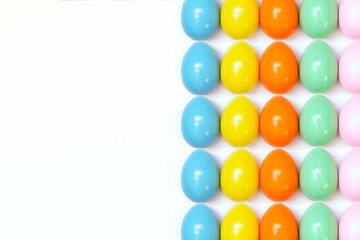 Top view of an Easter composition of painted eggs in bright juicy colors on a white background with a glossy texture that lie in even rows. Holiday concept, flat layout, background, advertisement.