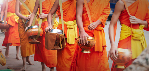 Buddhist monks carrying their alms bowls.