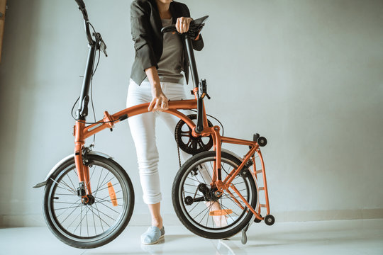 young entrepreneur woman prepares a folding bike from her home for daily transportation