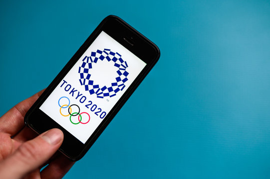 TOKYO, JAPAN, JANUARY. 20. 2020: Logo of the XXXII Summer Olympics games 2020 on a mobile phone screen. Blue Background