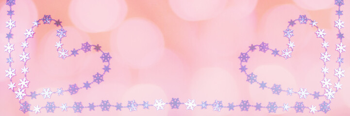 Creative wide Valentine's day banner with two heart of shiny lilac metallic snowflakes on pink background with bokeh. 