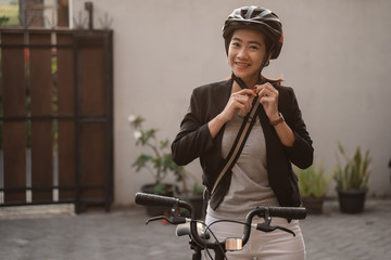 asian young woman wearing helmet bike for safety before go by bike to work