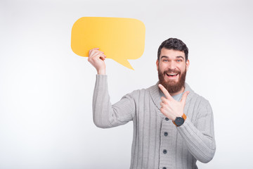 Look what's said here! Cheerful man is pointing at the yellow bubble speech he is holding!