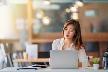 Portrait of young business woman working and thinking in the office	