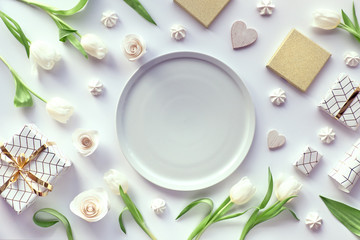 Spring flat lay, top view with white tulips, flowers, geometric decorations - coffee cups, gift...
