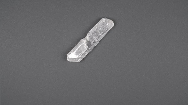 Mountain quartz crystal rotating on black background. Macro shot