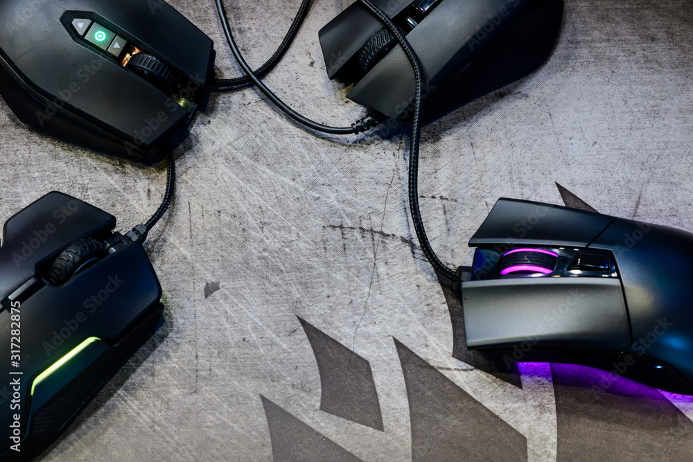 Poster close-up group of modern gaming mouse on black color with led rgb light show status on working mode 
