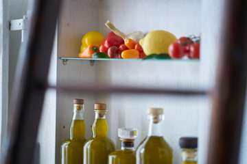 still life closeup vegetable in kitchen shelf detail bottles olive oil kitchen rural rustic country,glass deco gold food cooking natural nice  organic atmospheric