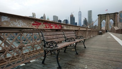 Rain-soaked bench on the deck of the Brooklyn Bridge in New York City 
