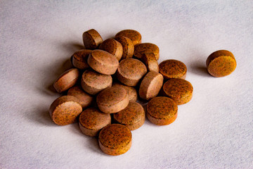 brown vitamin pills on a white background