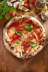 Pizza. Traditional italian pizza with ingredients on a wooden background viewed from above. Top view