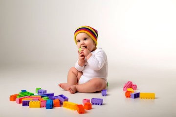 baby boy 9 months old playing with a multi-colored constructor on a white background. the concept of development of the child, space for text