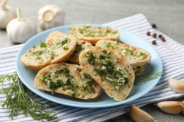 Plate with toasted garlic bread on grey background, close up
