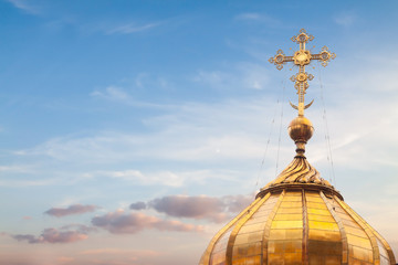 Fototapeta na wymiar Golden cross dome blue sky background easter spring sunset with copy space