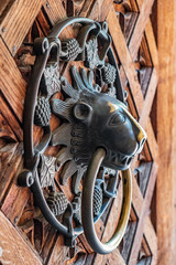 Symbolic lion-headed door knocker in the Middle Castle part of the Medieval Teutonic Order castle and monastery in Malbork, Poland - obrazy, fototapety, plakaty
