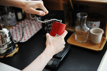 Manual coffee grinder in the hands. Home manual brewing still life. Third wave speialty coffee aesthetics