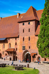 Fototapeta na wymiar Middle Castle fortress inner courtyard with the gate tower of the Medieval Teutonic Order Castle in Malbork, Poland