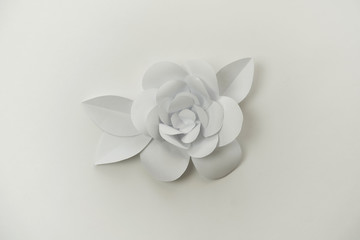Minimalistic white hand crafted flower with leaves close up photo.