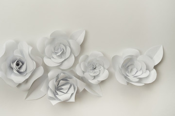 Monochromatic white paper flowers closeup photo. Hand crafted flowers on white.