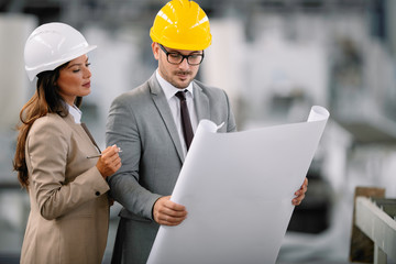 Architects working on construction project. Man and woman discussing work. 