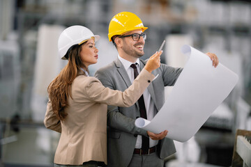 Architects working on construction project. Man and woman discussing work. 