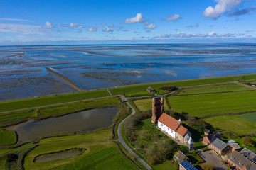 Blick auf das Wattenmeer von Pellworm/Deutschland mit der Alten Kirche vorne rechts