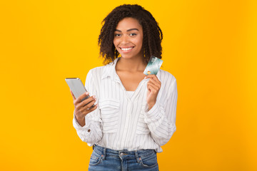Smiling afro woman holding card looking at camera