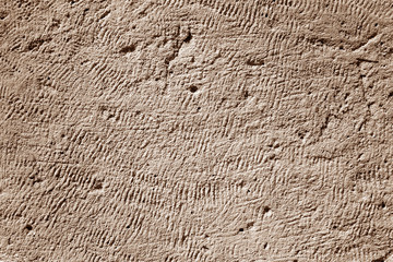 Sand stone uneven surface as background in brown tone.