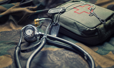 Stethoscope lies on the uniform of a US soldier. The concept of health care, military insurance, state care. Top view.