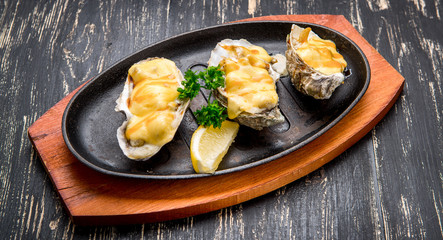 Oysters in a pan in a creamy sauce and cheese