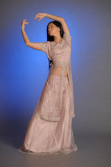 brunette girl in oriental dress on a blue background in the studio