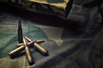 Few bullets lie against a khaki background. The concept of war, state defense, political conflict.