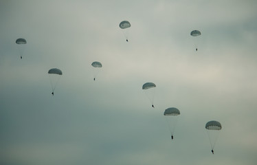 Army paratroopers jumping at air war action.