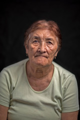 Obraz premium Portrait of an old woman against a dark background. Photographed close-up.