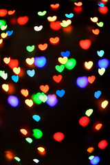 Heart. Abstract bokeh lights in colorful little heart shape on black background. Christmas  and valentines day. Blurred  vertical background.