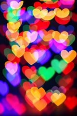 Heart. Abstract bokeh lights in colorful little heart shape on black background. Christmas  and valentines day. Blurred  vertical background.