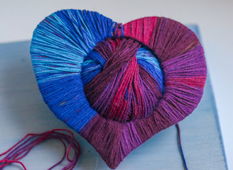 happy Valentines day still life card with woolen yarn thread heart , ball of thread and copy space on wooden board background