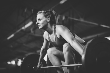 Fototapeta na wymiar Female fitness model doing cross fit power lifting exercises in a gym