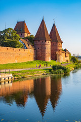 Naklejka na ściany i meble Panoramic view of the western gate with defense towers of the Medieval Teutonic Order Castle in Malbork, Poland at the Nogat river bank