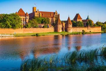 Naklejka na ściany i meble Panoramic view of the defense walls and towers of the Medieval Teutonic Order Castle in Malbork, Poland from across the Nogat river